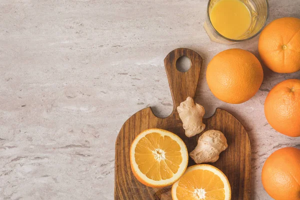 Vista superior de naranjas y jengibre para el jugo casero en la mesa - foto de stock