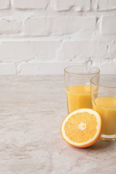 Homemade orange juice and orange on marble tabletop — Stock Photo