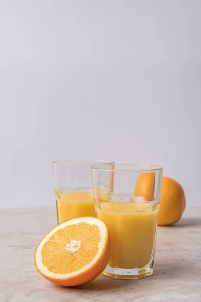Jus d'orange maison et oranges sur table en marbre — Photo de stock