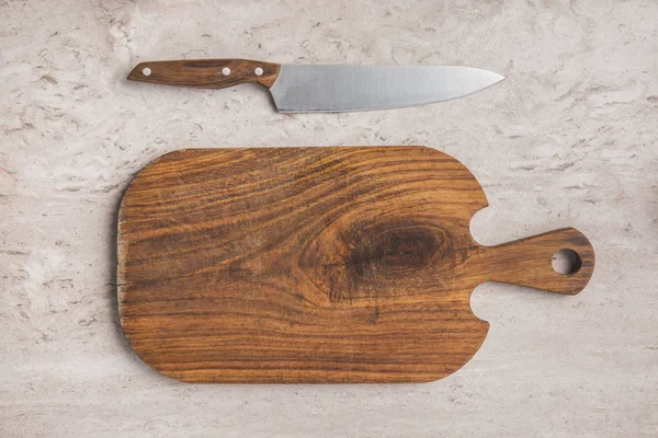 Top view of empty cutting board and knife on marble table — Stock Photo