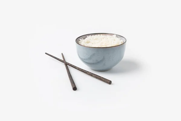 Bowl of rice with chopsticks on white tabletop — Stock Photo