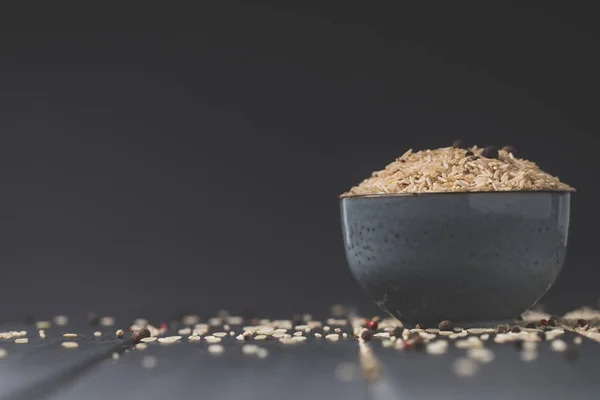 Миска сырого риса на черном столе с копировальным местом — стоковое фото