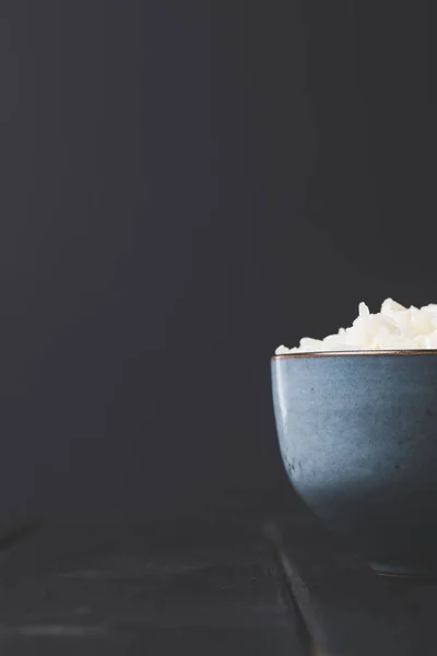Nahaufnahme einer Schüssel mit leckerem Reis auf schwarzem Tisch — Stockfoto