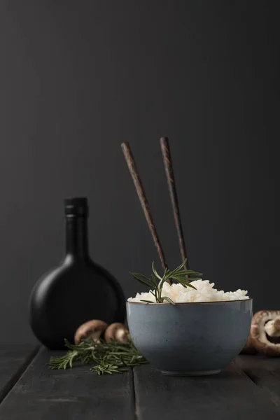 Миска вкусного риса с грибами и бутылка соевого блюдца черный стол — стоковое фото