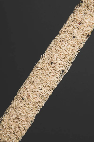 Bande diagonale de riz cru isolé sur noir — Photo de stock
