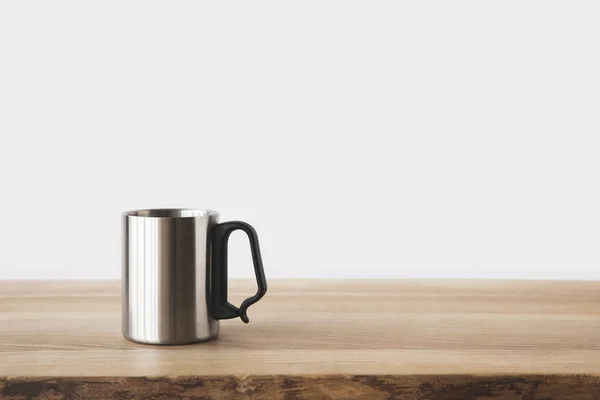 Одна серебряная чашка на деревянном столе на белом — стоковое фото