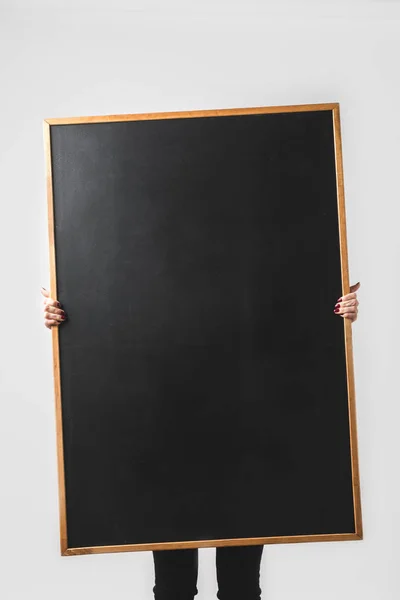 Woman holding big empty black board isolated on white — Stock Photo