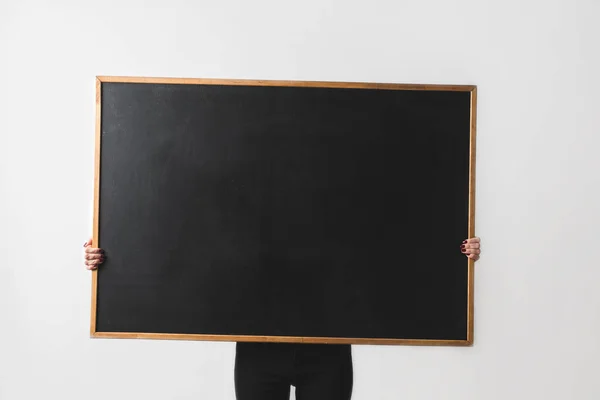 Woman holding big empty black board isolated on white — Stock Photo