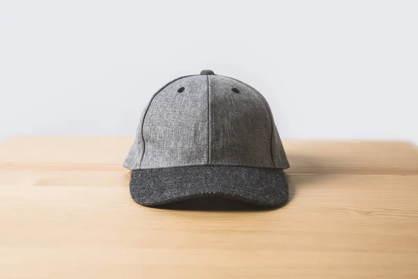 One grey cap on wooden table on white — Stock Photo