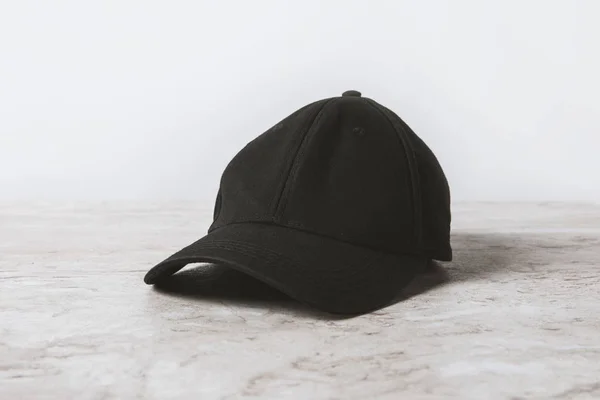 One black cap on wooden table on white — Stock Photo