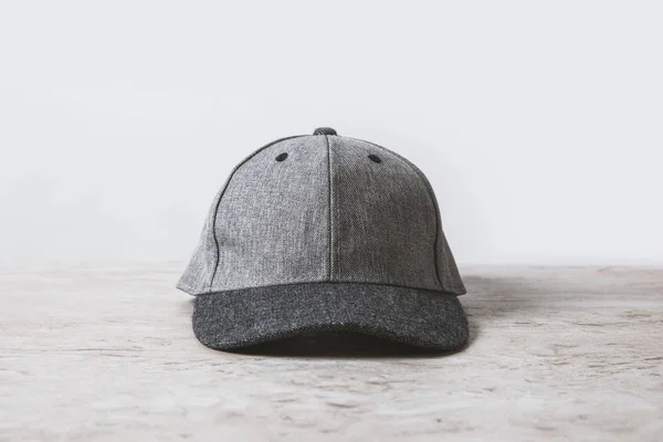 One grey cap on wooden table on white — Stock Photo