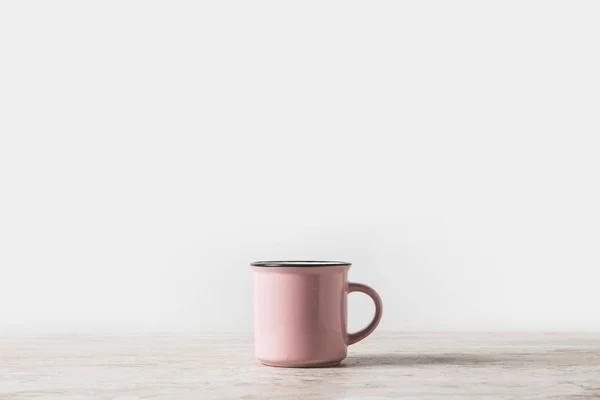 Une tasse rose sur table en marbre sur blanc — Photo de stock