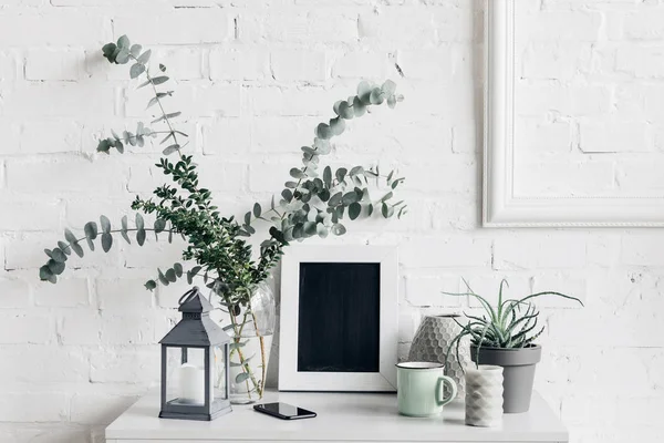 Plantes d'intérieur avec tableau blanc devant le mur de briques blanches, concept de maquette — Photo de stock