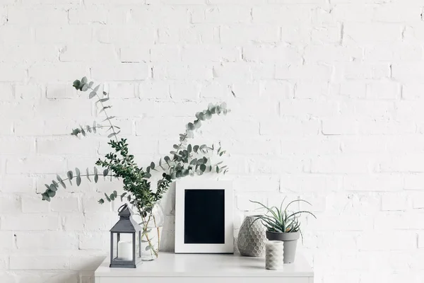 Plantas de sala com chalkboard pequeno em branco na frente da parede de tijolo branco, conceito de mockup — Fotografia de Stock