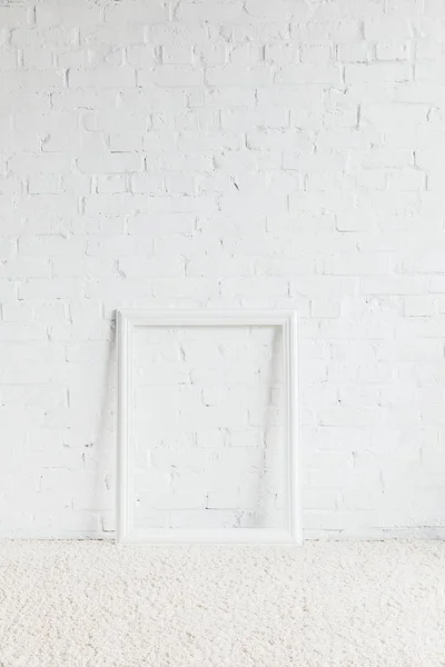 Empty frame in front of white brick wall, mockup concept — Stock Photo