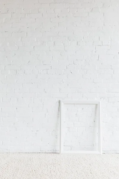 Marco vacío delante de la pared de ladrillo blanco, concepto de maqueta - foto de stock