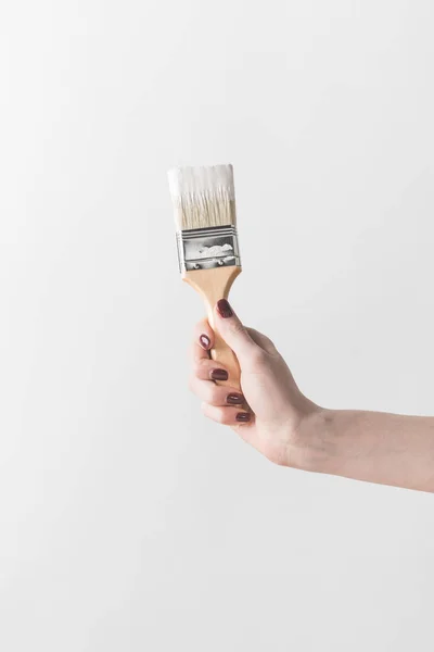 Imagem cortada de mulher segurando escova em tinta branca isolada em branco — Fotografia de Stock