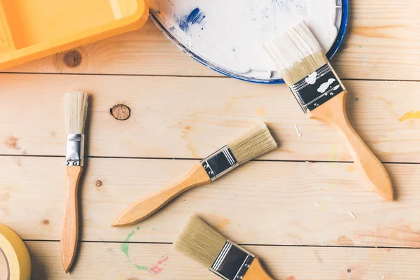 Top view of different brushes and plastic tray on wooden surface — Stock Photo