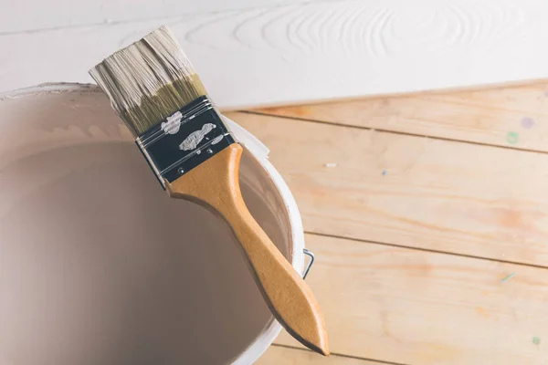 Brush on plastic bucket with white paint — Stock Photo