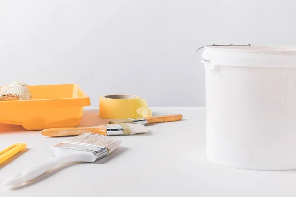 Bucket with paint and tools for repairs on surface — Stock Photo