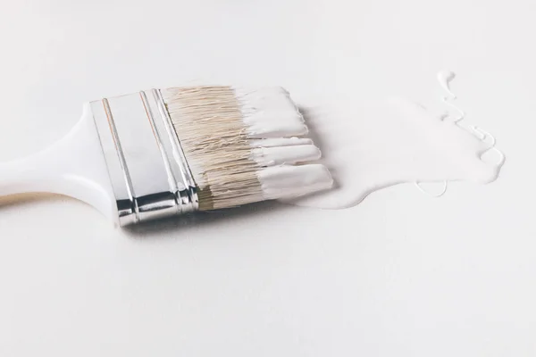 Un pennello in vernice bianca su superficie isolata su bianco — Foto stock