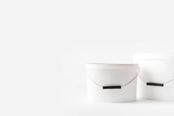 Dois baldes brancos de plástico com tintas isoladas em branco — Fotografia de Stock