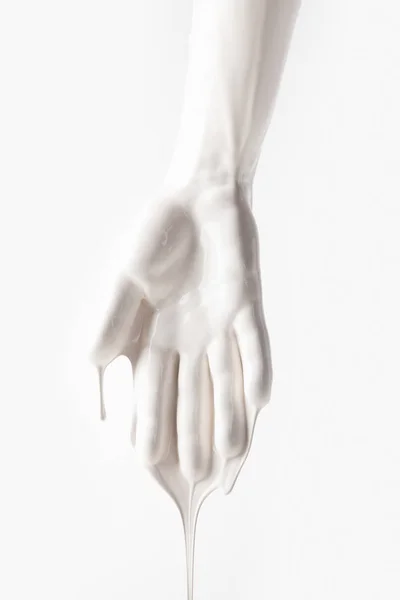 Imagen recortada de brazo femenino en pintura de goteo blanco aislada en blanco - foto de stock