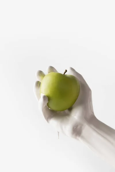 Cropped image of girl in white paint holding apple isolated on white — Stock Photo