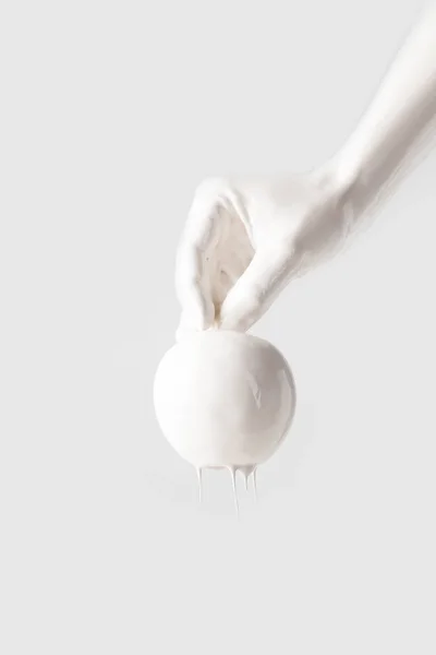 Cropped image of girl in white paint holding apple in hand isolated on white — Stock Photo