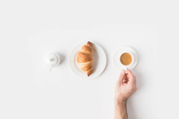 Tiro recortado de mano femenina y desayuno en la superficie blanca - foto de stock