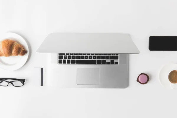 Flat lay with digital devices and breakfast on white tabletop — Stock Photo