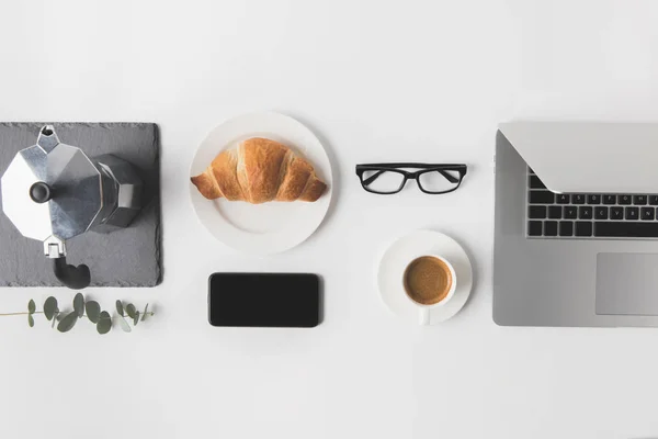 Flat lay com dispositivos digitais e pequeno-almoço em mesa branca — Fotografia de Stock