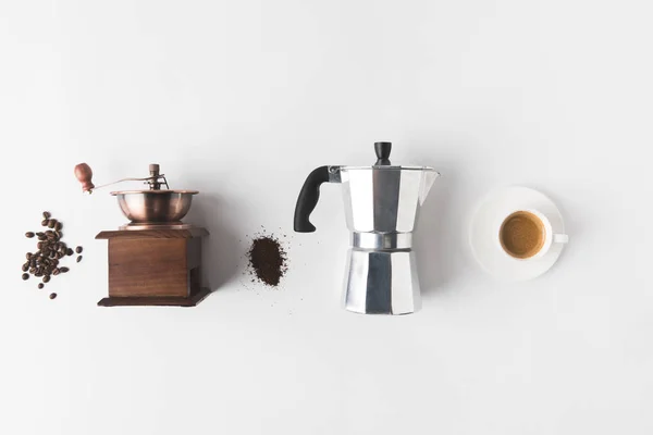 Вид зверху на організоване приладдя для приготування кави, інгредієнти та чашку кави на білому столі — стокове фото