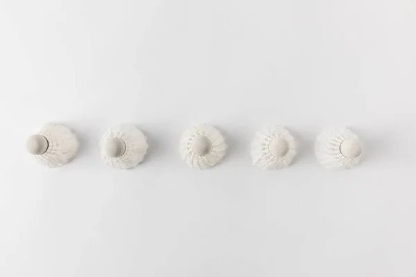 Top view of badminton shuttlecocks in row on white surface — Stock Photo