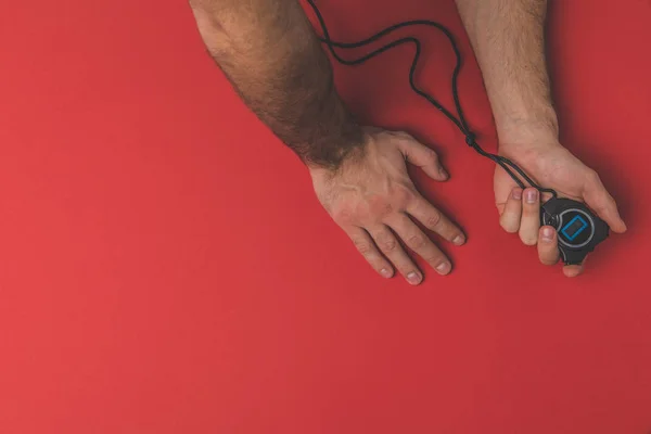 Cropped shot of sports trainer holding stopwatch on white surface — Stock Photo