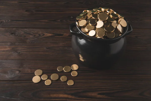 Високий кут зору горщика з золотими монетами на дерев'яному столі, концепція дня стрічки — стокове фото