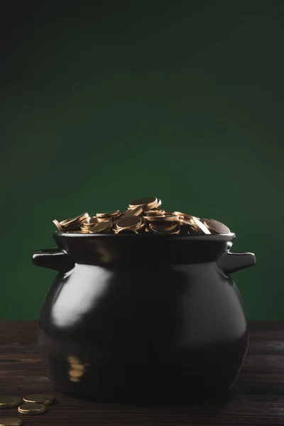 Topf mit goldenen Münzen auf Holztisch auf grünem, st patricks day concept — Stockfoto