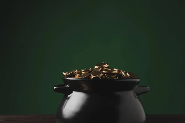 Topf mit goldenen Münzen auf Holztisch auf grünem, st patricks day concept — Stockfoto