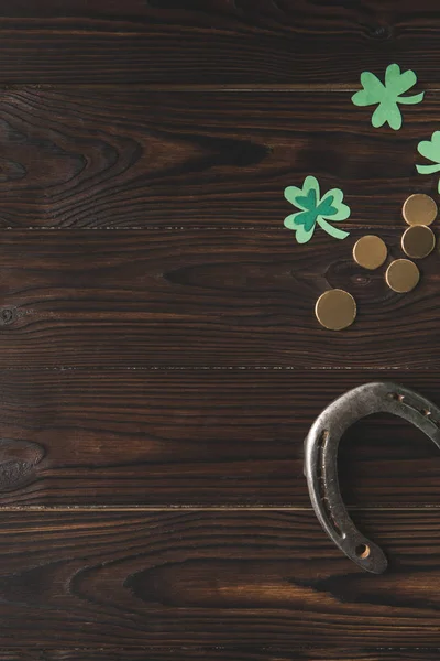 Top view of golden coins, horseshoe and shamrock on wooden table, st patricks day concept — Stock Photo