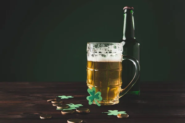 Стакан пива с трилистником и золотыми монетами на столе, день святого Патрика — стоковое фото