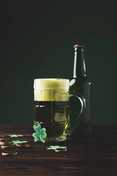 Vaso de cerveza con trébol y monedas de oro en la mesa, San Patricio concepto de día - foto de stock
