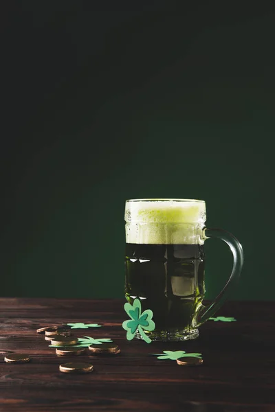 Copo de cerveja com trevo e moedas de ouro na mesa de madeira, st patricks conceito dia — Fotografia de Stock