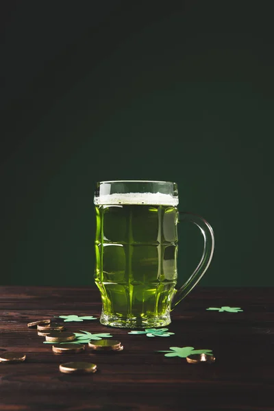 Glass of beer with shamrock and golden coins on wooden table, st patricks day concept — Stock Photo