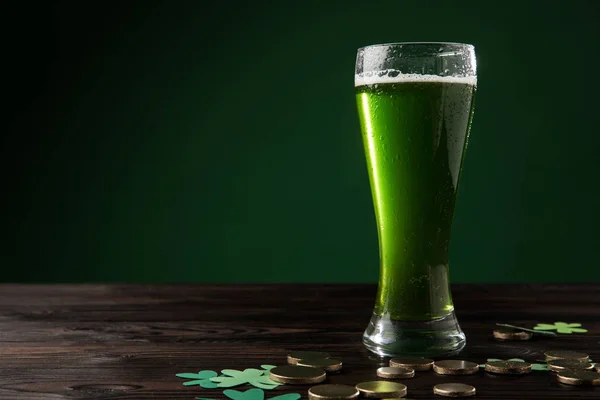 Vaso de cerveza verde con trébol y monedas de oro en la mesa, San Patricio concepto de día - foto de stock