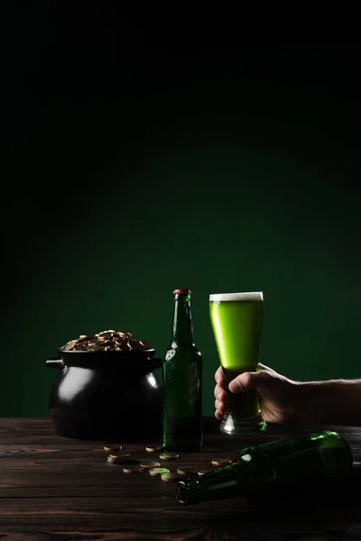 Обрізане зображення людини, що тримає склянку зеленого пива, концепція святкового дня — стокове фото