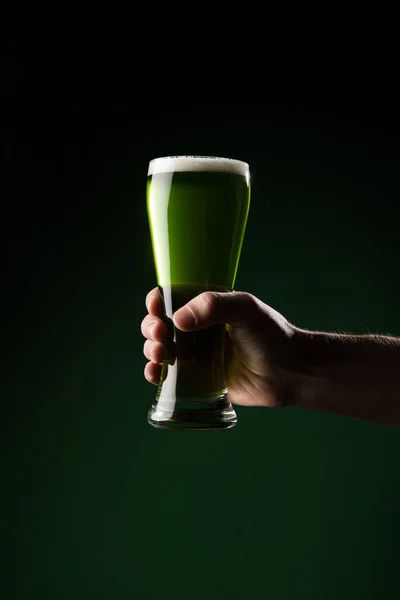 Imagen recortada del hombre sosteniendo vaso de cerveza verde, San Patricio concepto de día - foto de stock