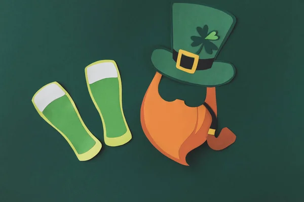 Vista superior de la decoración de papel del hombre con pipa de fumar para st patricks día aislado en verde - foto de stock