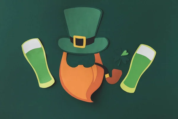 Vista superior de la decoración de papel de duende y cerveza para San Patricio día aislado en verde - foto de stock