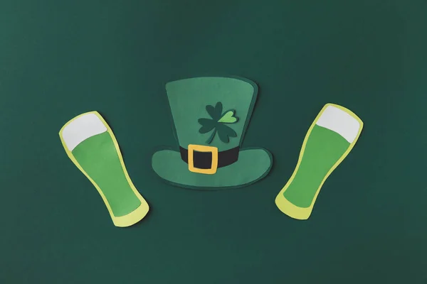 Vue du dessus de la décoration en papier de chapeau vert et de bière pour st patricks jour isolé sur vert — Photo de stock