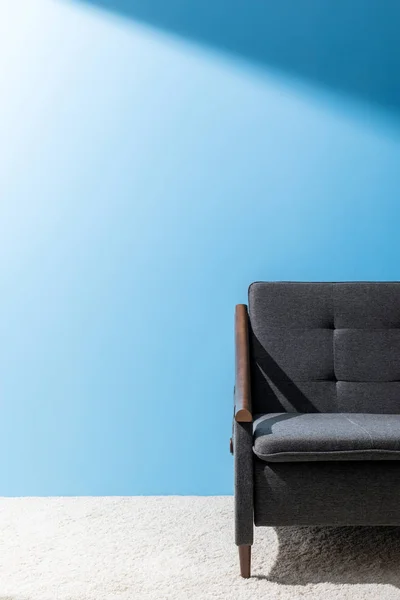 Bequeme graue Couch vor blauer Wand — Stockfoto